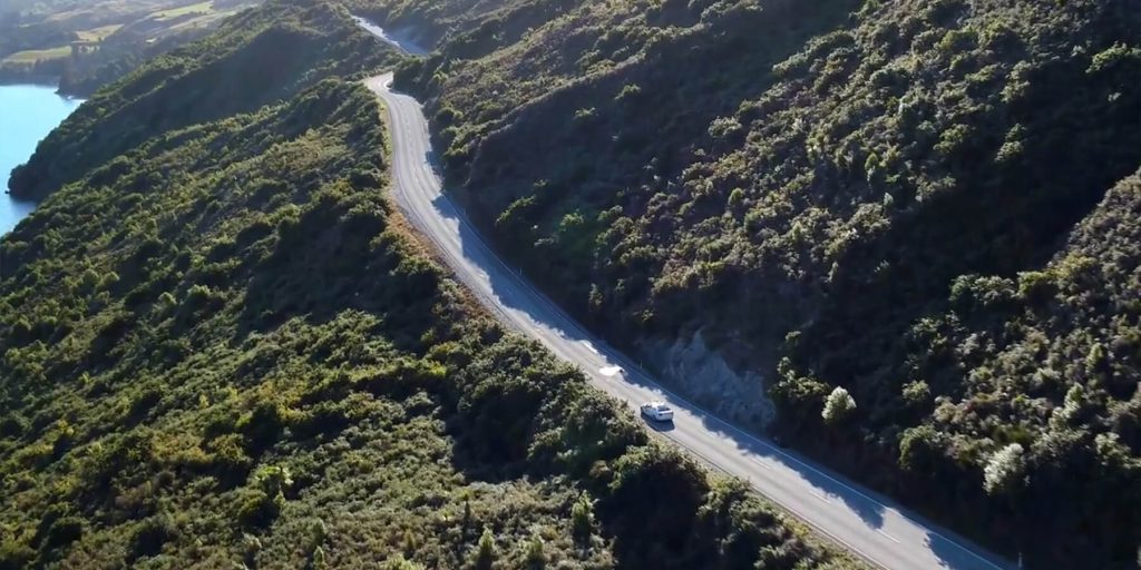 Aerial view of a road winding through native bush